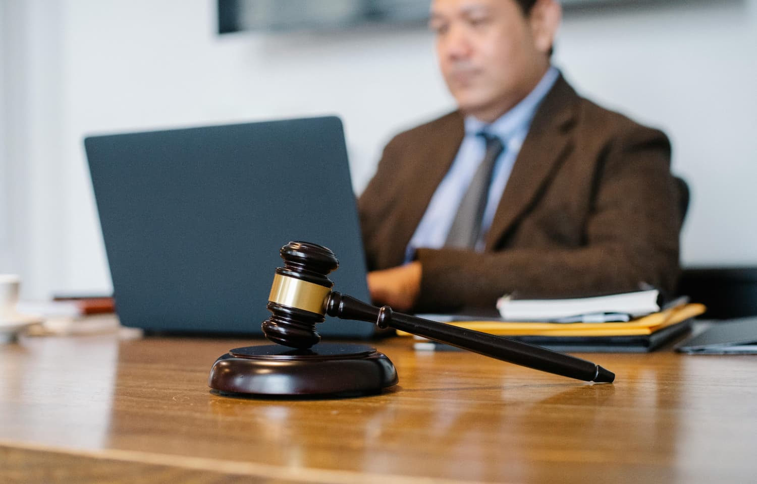 Asian judge working on laptop in office.